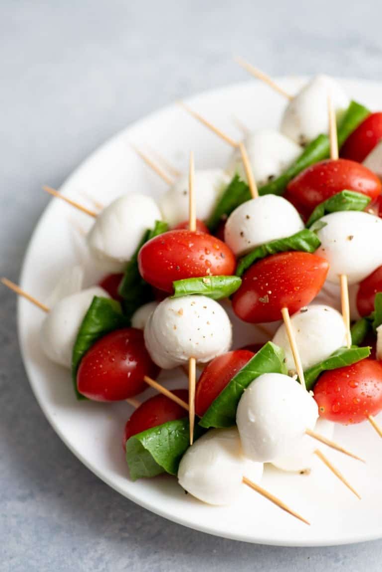 Side angle shot of Caprese Sticks on a white plate