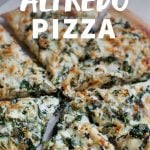 Homemade pizza cut into slices. A text overlay reads "Chicken Spinach Alfredo Pizza."