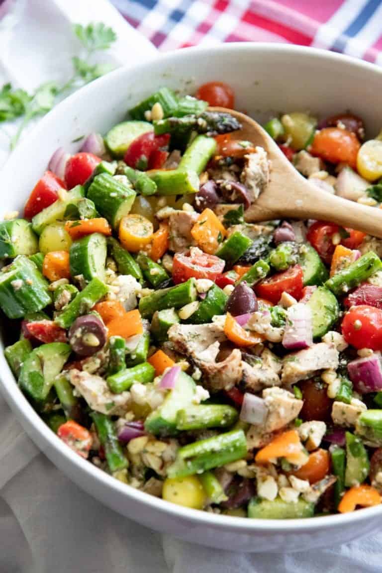 Side angle shot of Grilled Chicken and Asparagus Chopped Greek Salad in a white bowl