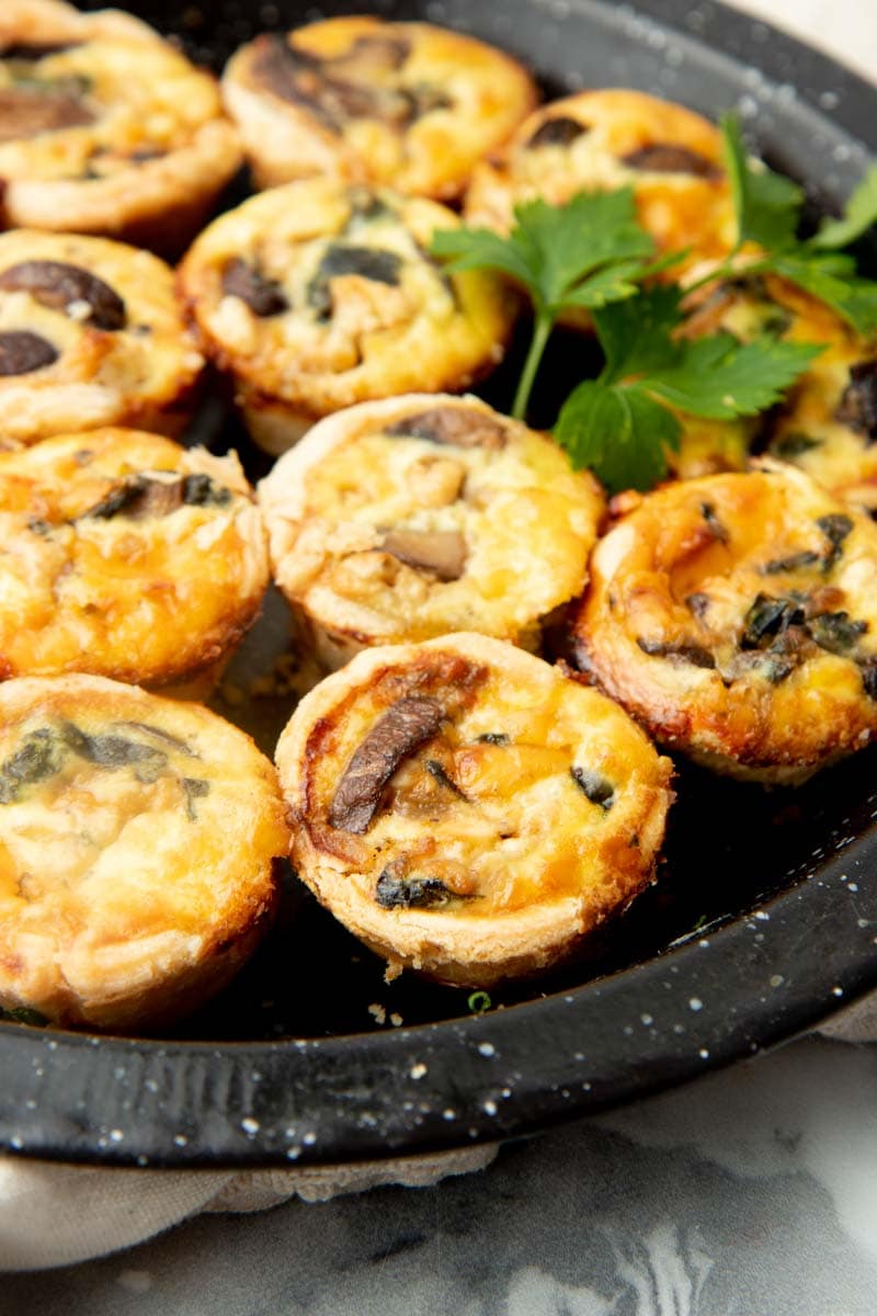 Close up of mini spinach and feta appetizers on a platter.