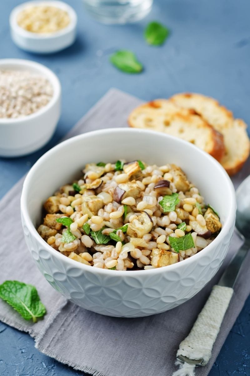 Finished barley recipe in a bowl on a blue table.