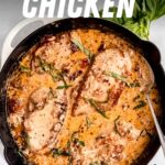 A creamy chicken skillet garnished with fresh basil rests on a light countertop. A text overlay reads, "Marry Me Chicken. Creamy Sundried Tomato Chicken."