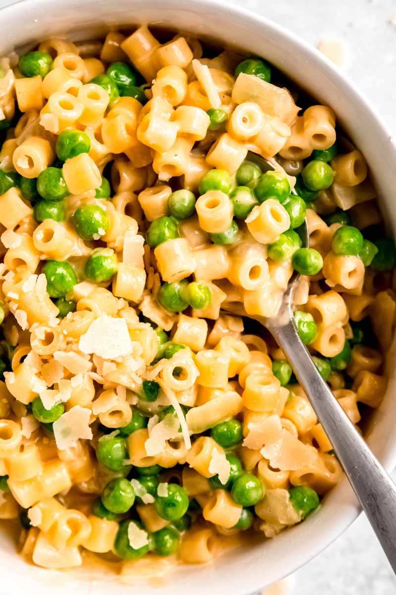 Close view of a spoon scooping into a bowl of noodles.