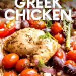 Front view of greek sheet pan chicken and vegetables such as grape tomatoes, onions, bell peppers, and asparagus. A text overlay reads, "Sheet Pan Greek Chicken."