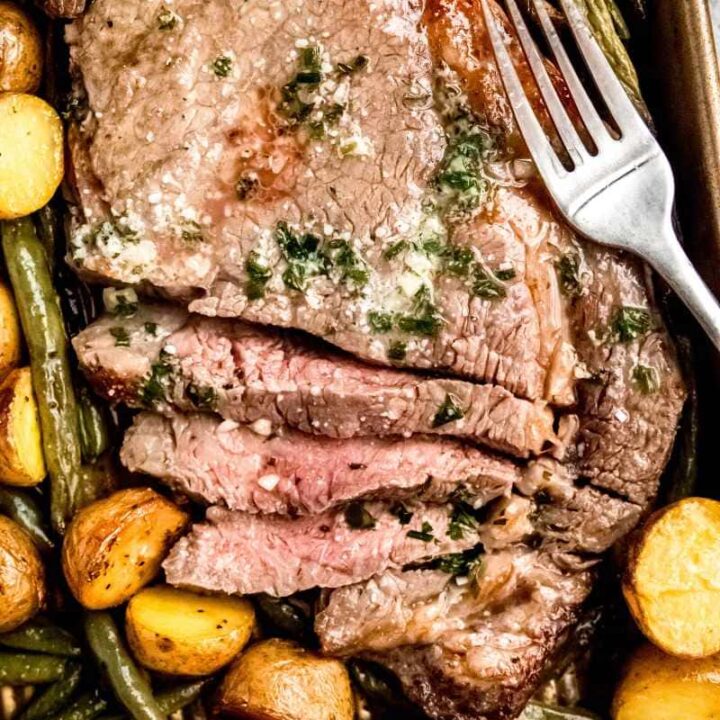 Overhead of a steak sheet pan dinner with veggies and a fork.