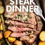 Overhead of a steak sheet pan dinner with veggies and a fork. A text overlay reads, "Sheet Pan Steal Dinner."