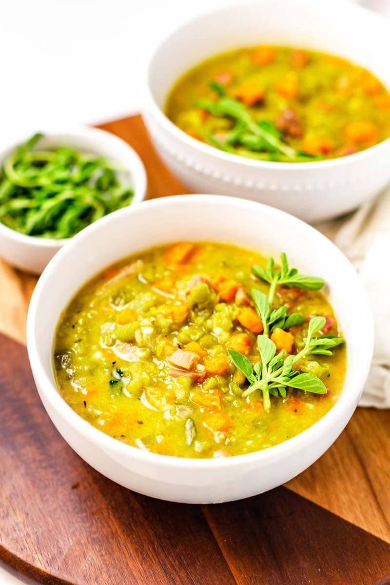 Bowl of split soup with ham garnished with fresh marjoram.