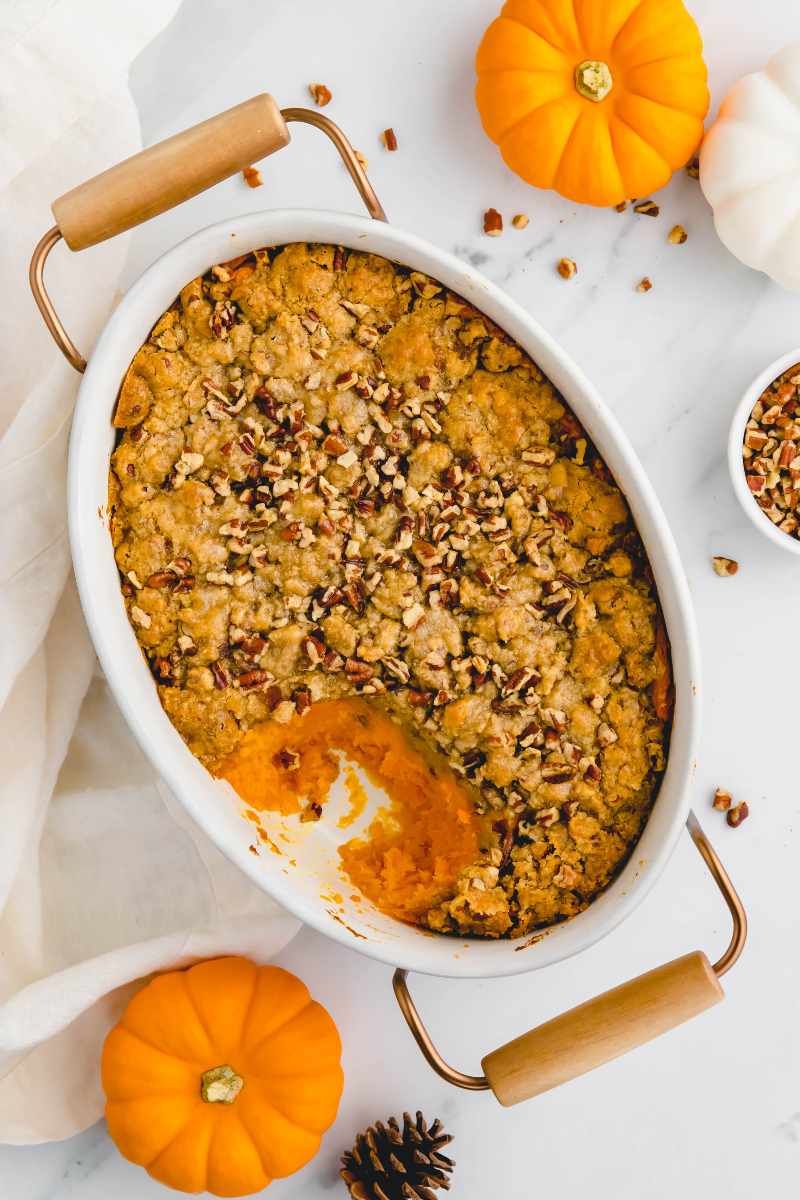 Overhead of a Thanksgiving casserole with a spoonful scooped out showing the filling beneath the topping.